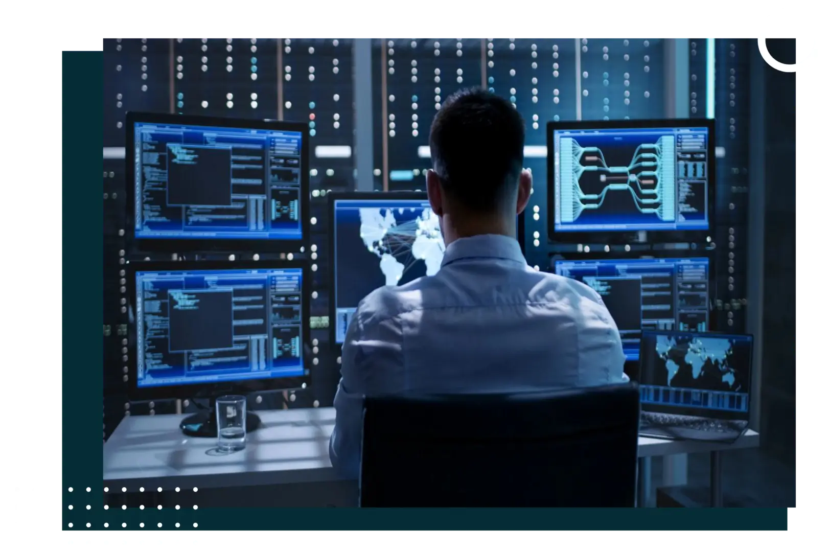 A man sitting in front of multiple computer screens.